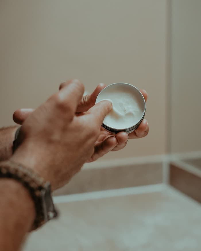 Hand scooping out beard balm